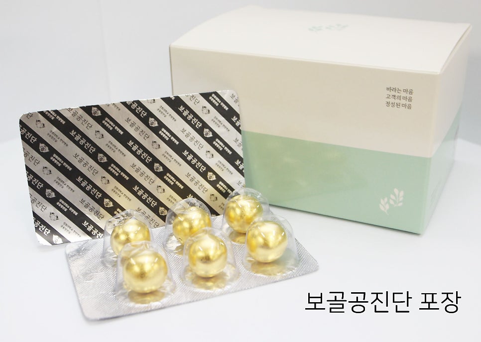 흰색과 연두색 상자 앞에 금색 환약이 담긴 블리스터 팩과 은색 포장지가 놓여 있다 — 서울 바로한의원 초음파 약침·도침