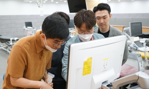 여러 명이 초음파 진단기기 모니터를 보며 실습 교육을 받고 있으며, 한 명이 초음파 탐촉자를 들고 있습니다 — 초음파 유도하 약침 시술 | 서울 바로한의원