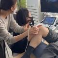 한 사람이 다른 사람의 목을 진찰하고 있으며, 뒤편에 초음파 기기가 놓여 있다 — 초음파 정밀 진단 | 서울 바로한의원 초음파 약침·도침·침도