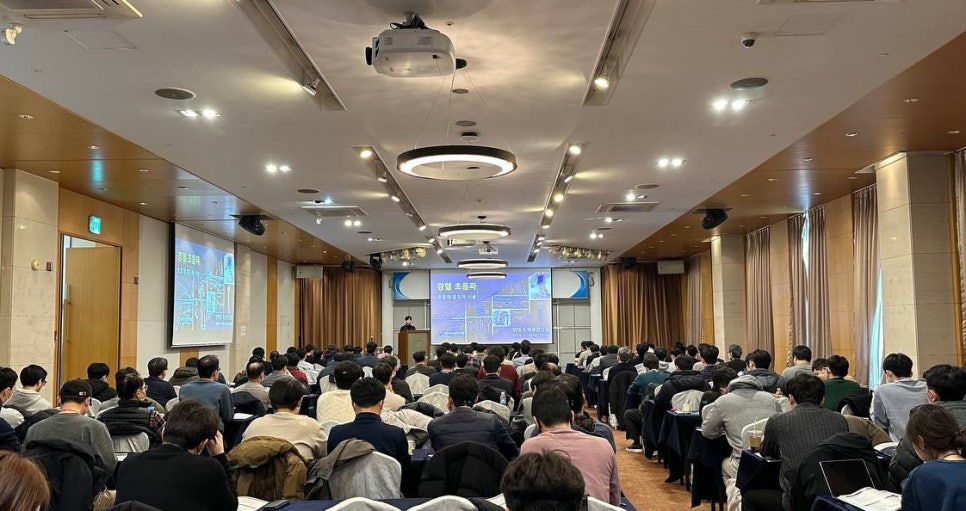 강당에서 많은 사람들이 강연을 듣고 있는 모습. 스크린에는 '경혈 초음파'라는 글자와 초음파 이미지가 보인다 — 대한한의영상학회 초음파 약침·도침 강의 | 서울 바로한의원