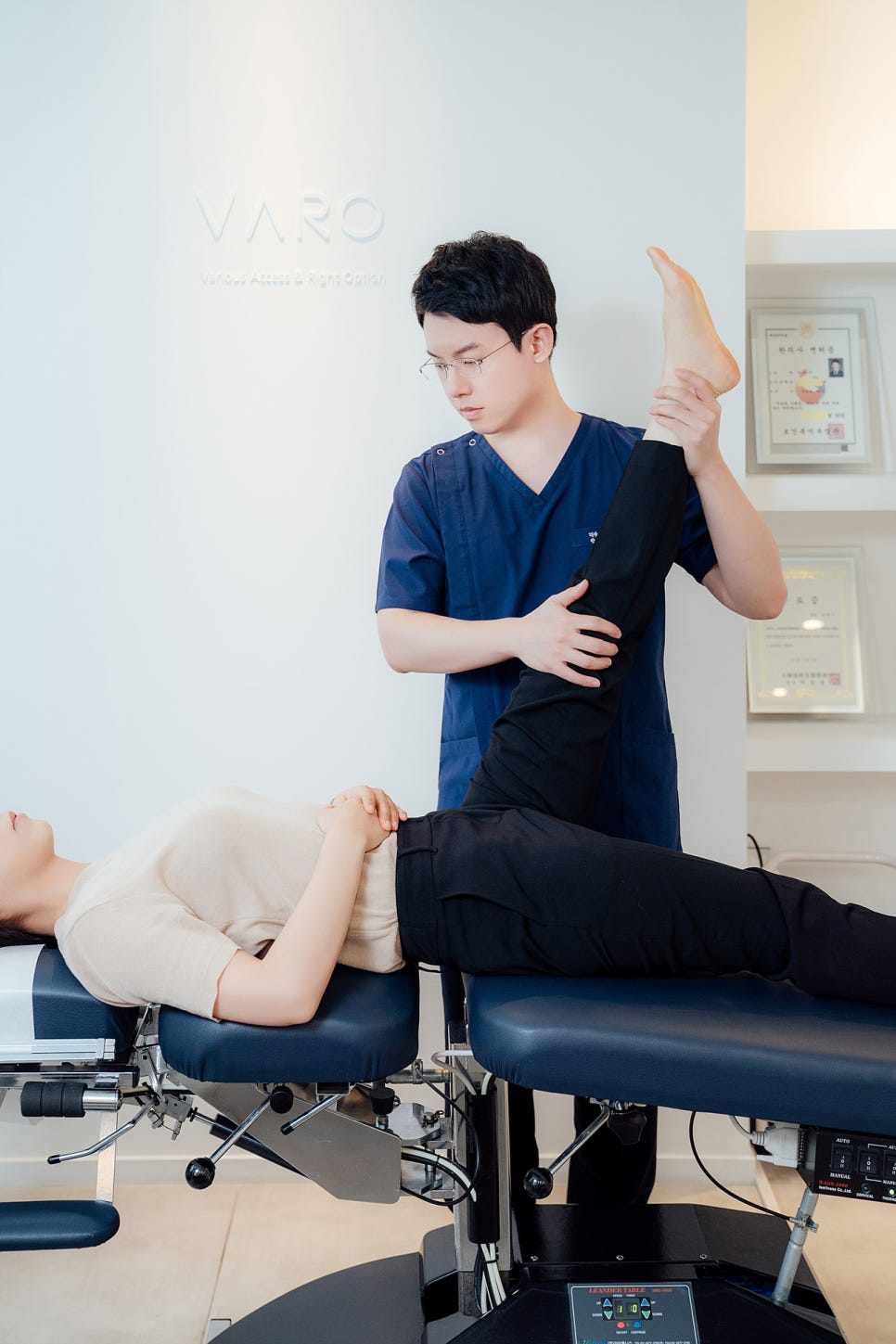 한의사가 치료대 위에 누운 환자의 다리를 잡고 스트레칭을 하고 있다 — 서울 바로한의원 초음파 약침·도침