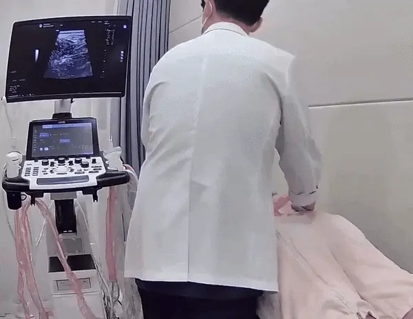 의사가 환자의 허리 부위를 초음파 기기로 검사하고 있으며, 초음파 화면이 보인다 — 초음파 정밀 진단 | 서울 바로한의원 초음파 약침·도침·침도
