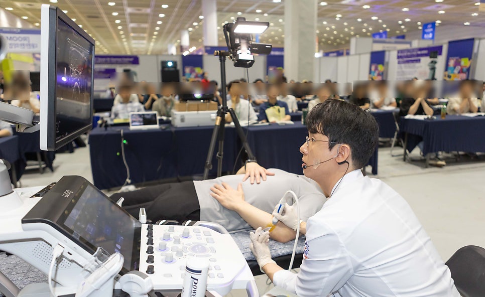 한의사가 환자의 팔에 초음파 기기를 대고 초음파 화면을 보며 시술하는 모습 — 초음파 유도하 약침 시술 | 서울 바로한의원