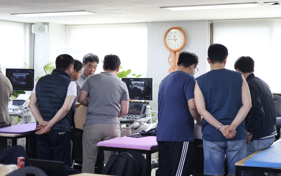 여러 명이 초음파 기기 화면을 보며 실습하는 모습 — 대한한의영상학회 초음파 약침·도침 강의 | 서울 바로한의원
