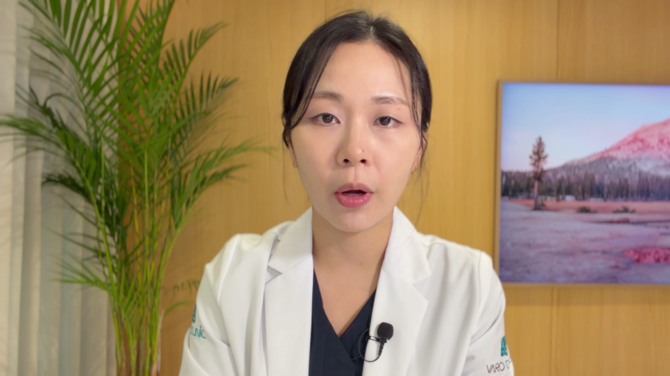 흰색 의사 가운을 입은 여성이 카메라를 보고 말하고 있으며, 배경에는 식물과 액자가 보인다 — 서울 바로한의원 초음파 약침·도침