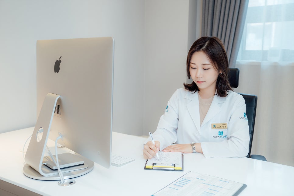 한의사 한 명이 책상에 앉아 서류에 펜으로 글을 쓰고 있다 — 서울 바로한의원 초음파 약침·도침