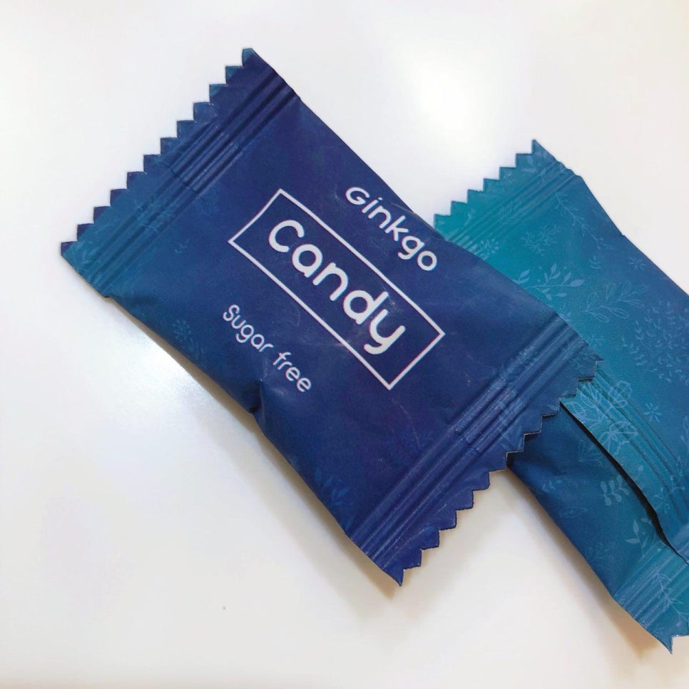 흰색 배경에 놓인 두 개의 개별 포장된 캔디. 앞쪽 캔디 포장지에는 'ginkgo Candy Sugar free'라고 쓰여 있다 — 서울 바로한의원 초음파 약침·도침