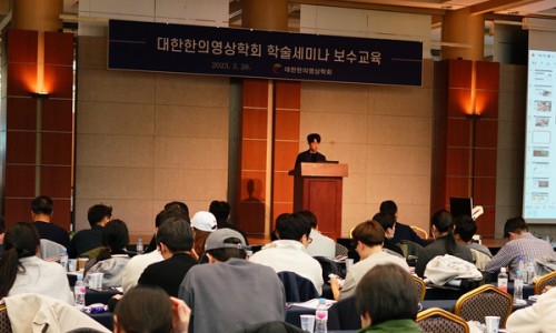 강사가 연단에서 발표하고 있으며, 청중들이 앉아 세미나를 듣고 있는 모습 — 대한한의영상학회 초음파 약침·도침 강의 | 서울 바로한의원