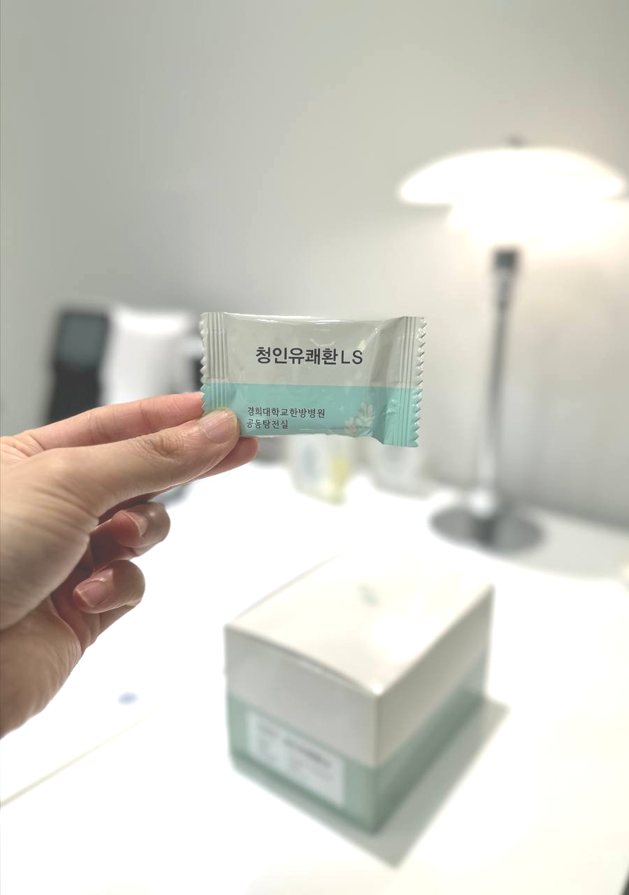손이 '청인유쾌환 LS'라고 적힌 작은 포장지를 들고 있다 — 서울 바로한의원 초음파 약침·도침