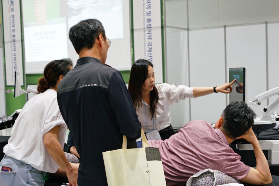 한 여성이 초음파 기기 화면을 가리키며 설명하고 있고, 여러 사람이 이를 지켜보고 있다 — 대한한의영상학회 초음파 약침·도침 강의 | 서울 바로한의원 문지현 원장