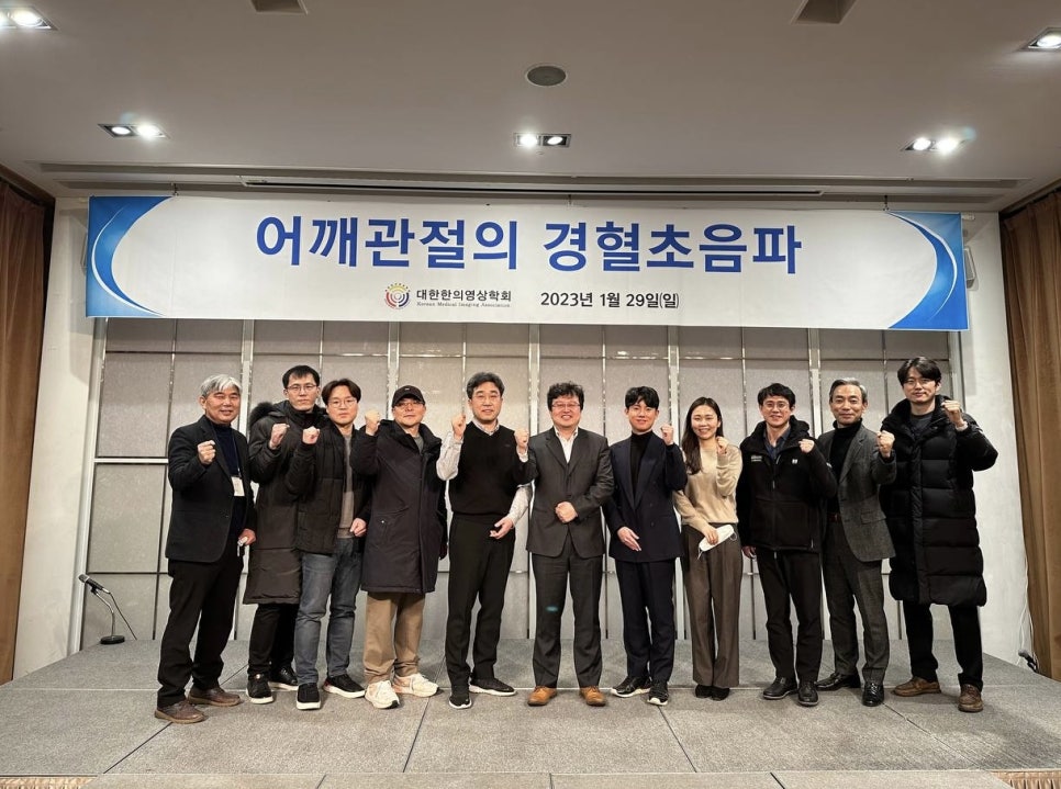 대한한의영상학회 어깨 경혈초음파 보수교육에 참석한 사람들이 현수막 앞에서 주먹을 쥐고 서 있는 모습 — 대한한의영상학회 초음파 약침·도침 강의 | 서울 바로한의원