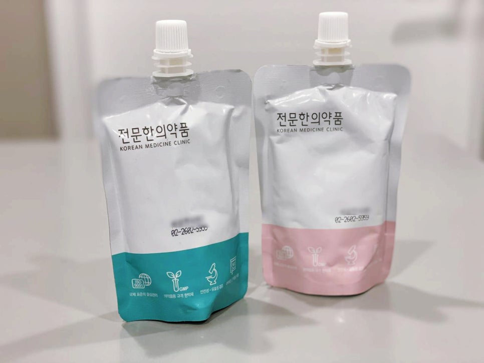 스크류 캡이 달린 흰색 파우치 두 개가 나란히 놓여 있습니다. 한 파우치는 하단이 청록색이고 다른 파우치는 하단이 분홍색입니다 — 서울 바로한의원 초음파 약침·도침