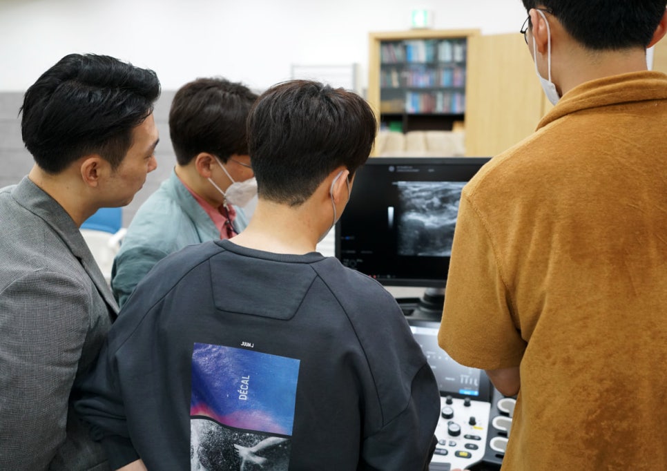 여러 사람이 초음파 모니터를 보며 화면 속 초음파 영상을 관찰하고 있다 — 대한한의영상학회 초음파 약침·도침 강의 | 서울 바로한의원