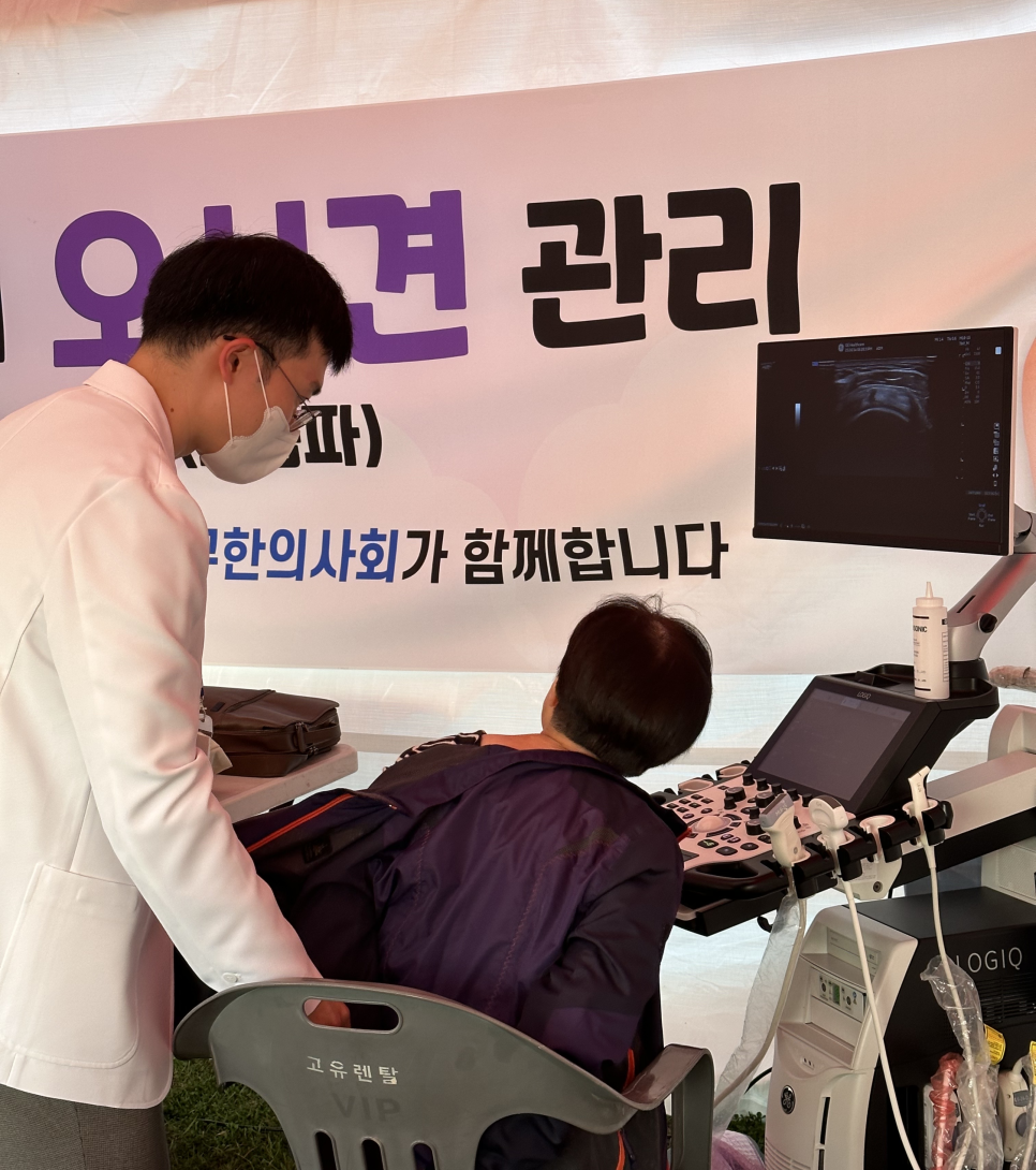 야외 부스에서 한의사가 환자의 등에 초음파 검사를 하는 모습과 초음파 화면 — 초음파 정밀 진단 | 서울 바로한의원 초음파 약침·도침·침도