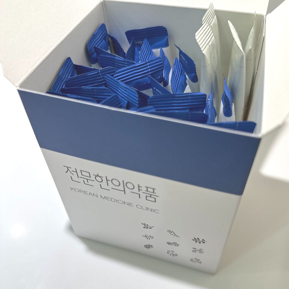 파란색 띠가 있는 흰색 상자에 개별 포장된 파란색과 흰색 약봉투들이 담겨 있습니다 — 서울 바로한의원 초음파 약침·도침