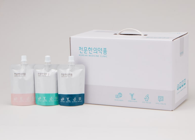 한의원 로고가 인쇄된 파우치 세 개와 흰색 상자가 흰 배경에 놓여 있다 — 서울 바로한의원 초음파 약침·도침