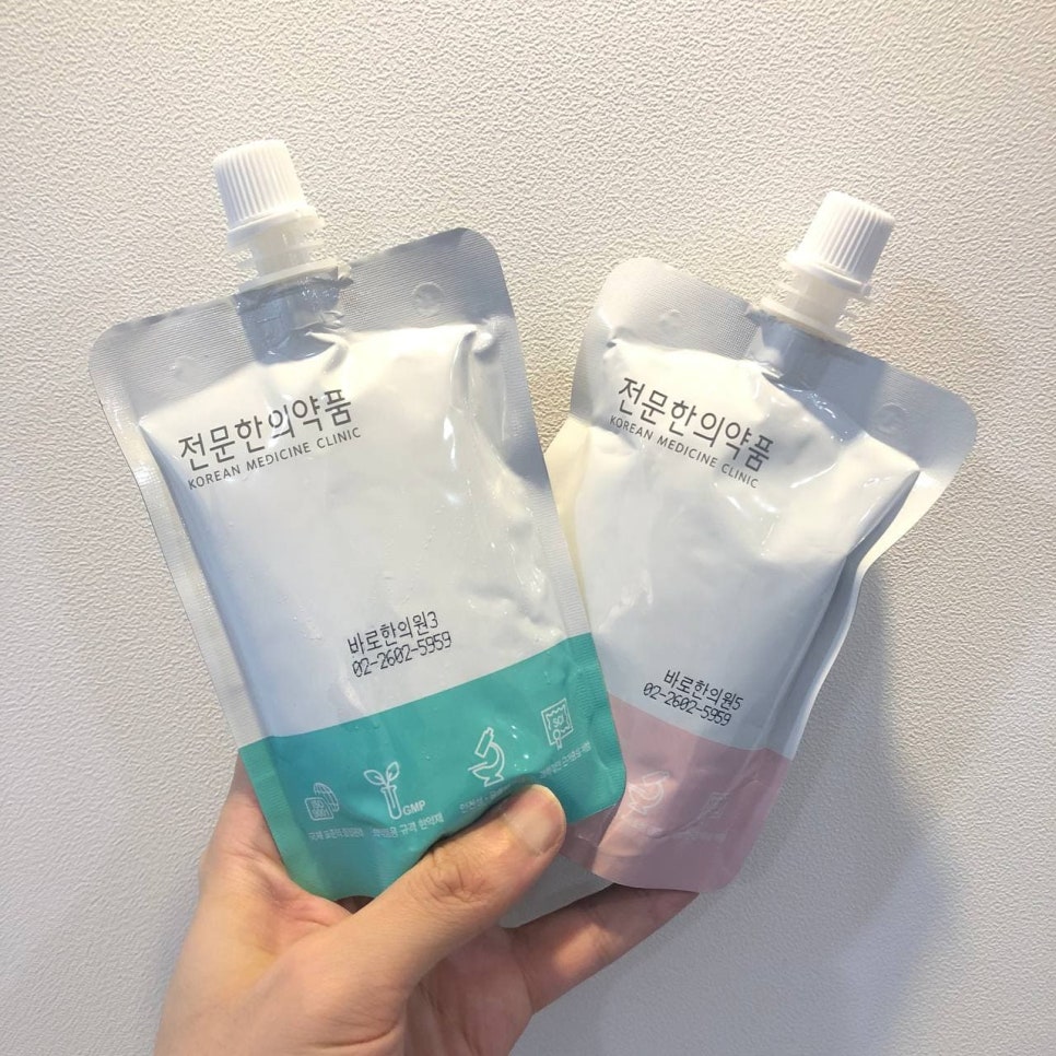 한 손이 '전문한의약품'이라고 적힌 초록색과 분홍색 파우치 두 개를 들고 있다 — 초음파 약침·도침 임상 논문 | 서울 바로한의원