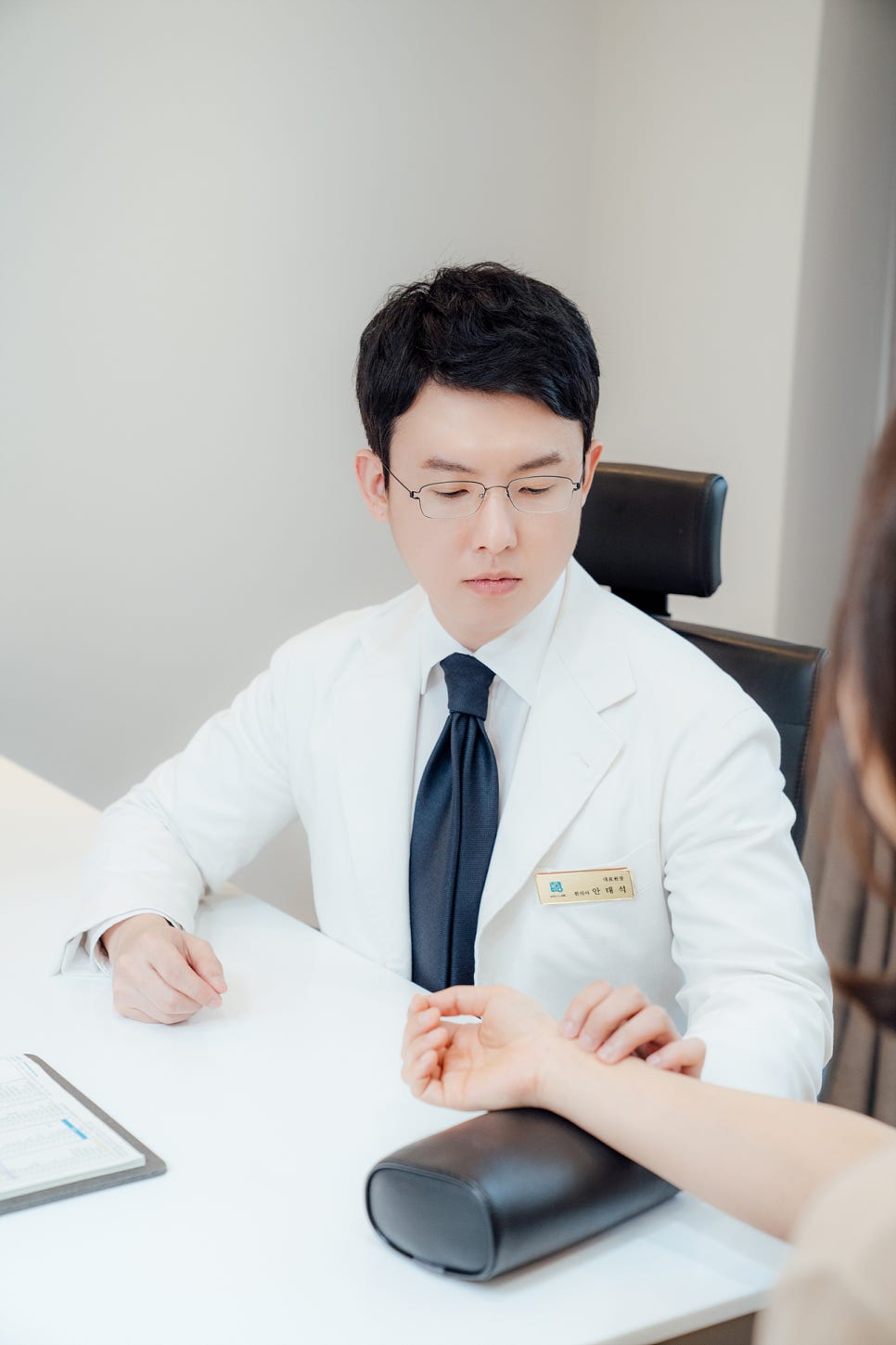한의사가 환자의 손목에서 맥을 짚고 있다 — 서울 바로한의원 초음파 약침·도침