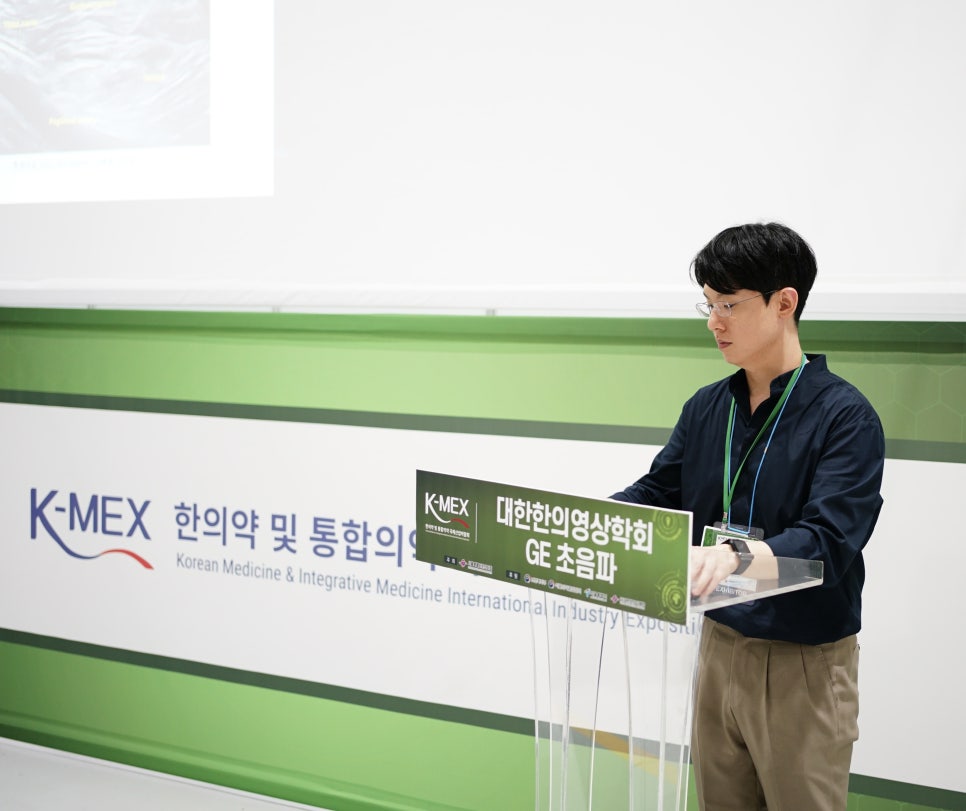 한의학 및 통합의학 학회에서 초음파 관련 안내판이 놓인 연단에 서 있는 남자 — 대한한의영상학회 초음파 약침·도침 강의 | 서울 바로한의원 안태석 원장