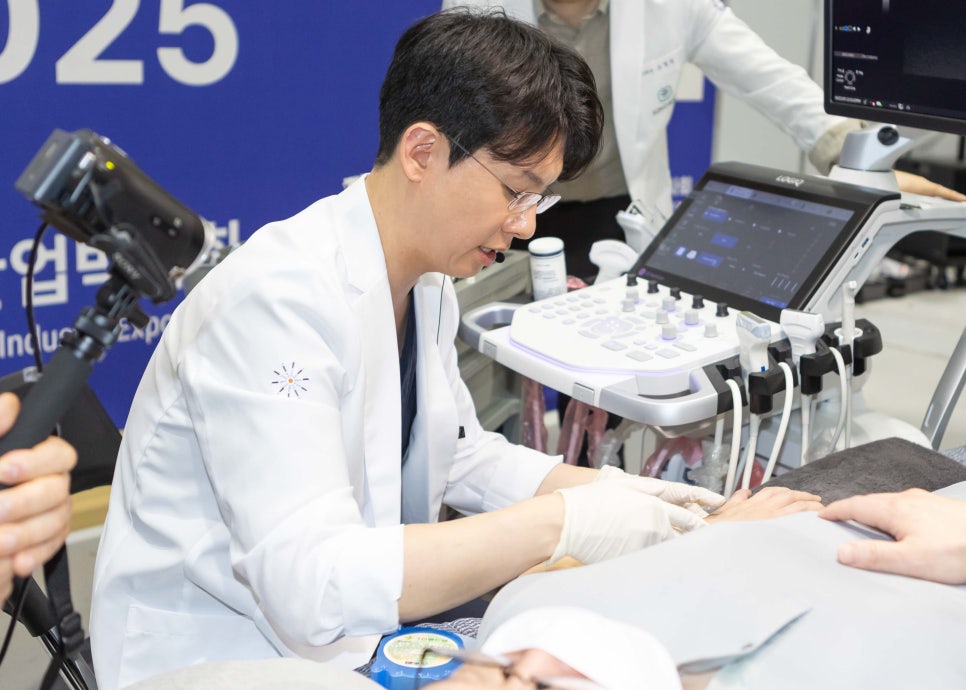 흰 가운을 입은 한의사가 초음파 기기를 사용하여 환자의 팔에 시술하는 모습 — 초음파 유도하 약침 시술 | 서울 바로한의원