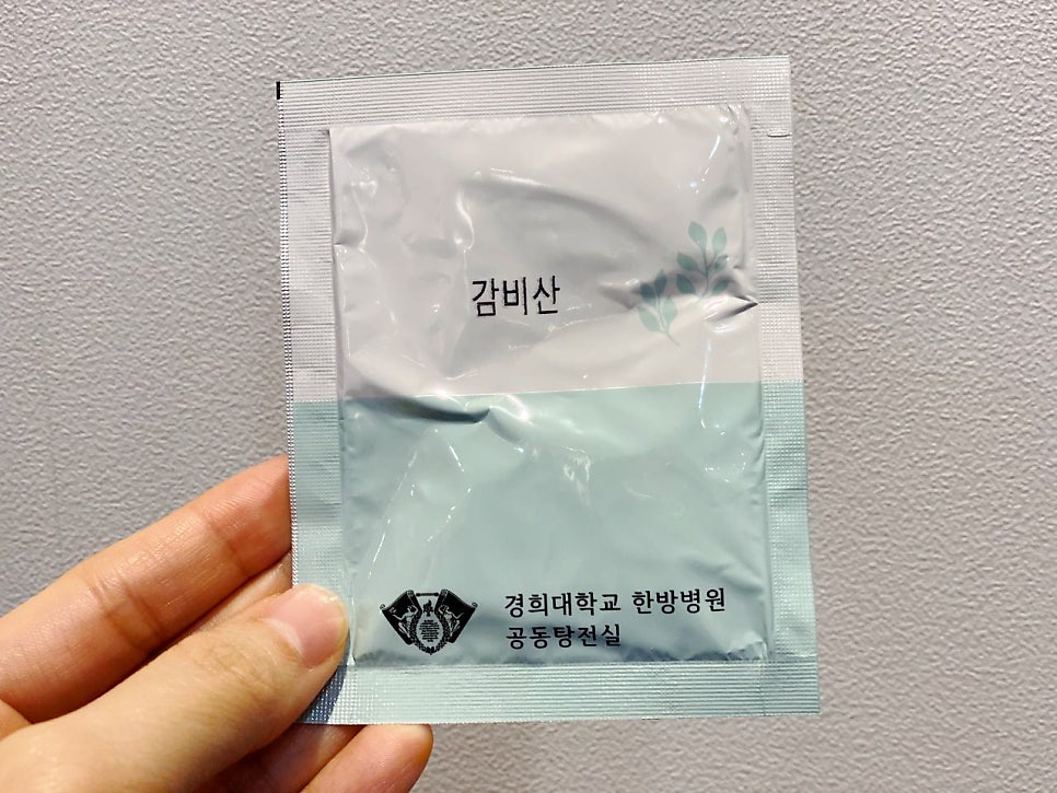 손이 경희대학교 한방병원 감비산 약 포를 들고 있는 모습 — 서울 바로한의원 초음파 약침·도침