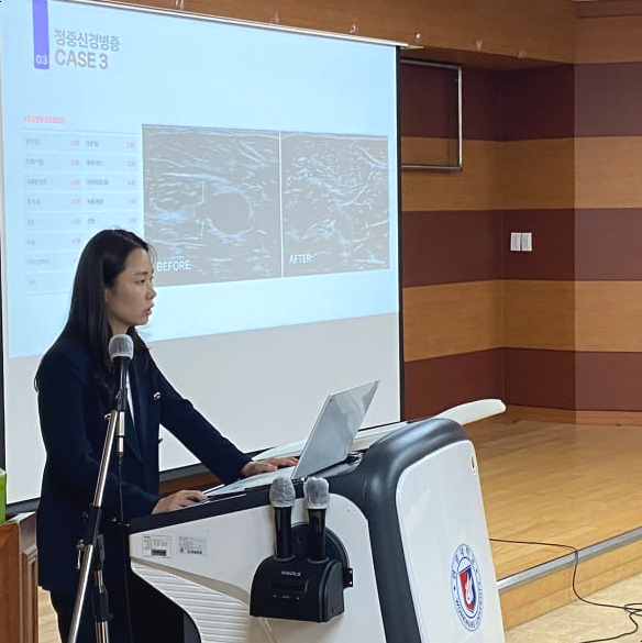 여성이 강단에서 발표하고 있으며, 스크린에는 결절종 치료 전후 초음파 사진을 포함한 의학 사례가 보인다 — 대한한의영상학회 초음파 약침·도침 강의 | 서울 바로한의원 문지현 원장