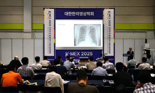 강당에서 강사가 청중에게 흉부 엑스레이 이미지를 보여주며 강의하고 있다 — 대한한의영상학회 초음파 약침·도침 강의 | 서울 바로한의원