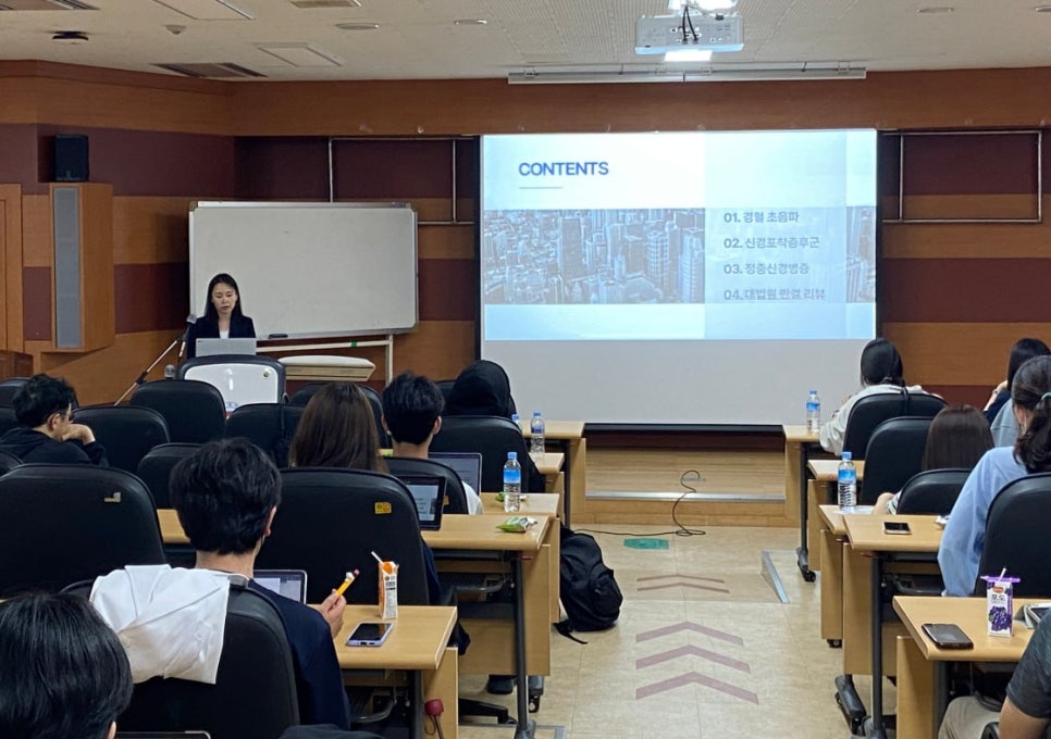 강의실에서 발표자가 화면에 내용을 띄우고 강연하는 모습과 청중들 — 대한한의영상학회 초음파 약침·도침 강의 | 서울 바로한의원