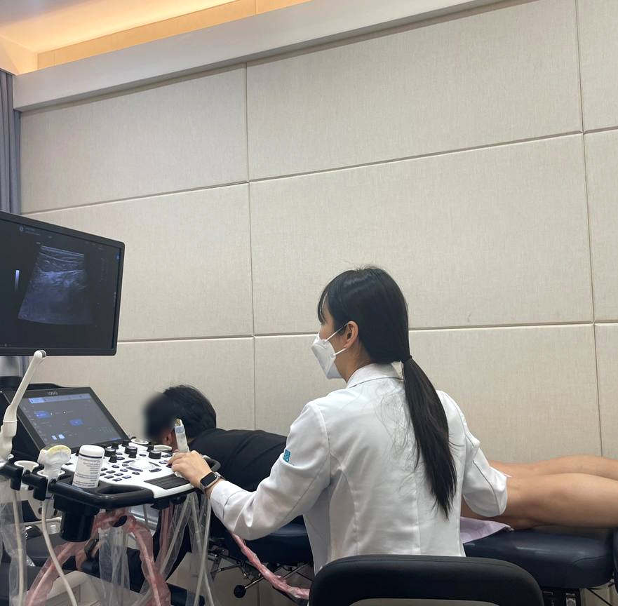 의료진이 초음파 기기를 사용하여 환자의 무릎 뒤쪽 부위에 도침 시술을 하고 있다 — 초음파 유도하 약침 시술 | 서울 바로한의원