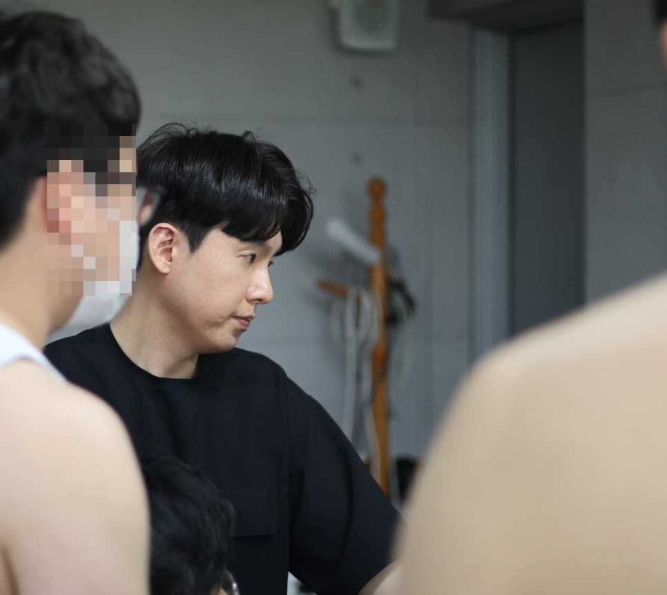 검은색 상의를 입은 남성이 다른 사람들과 함께 아래를 내려다보고 있는 모습 — 대한한의영상학회 초음파 약침·도침 강의 | 서울 바로한의원 안태석 원장