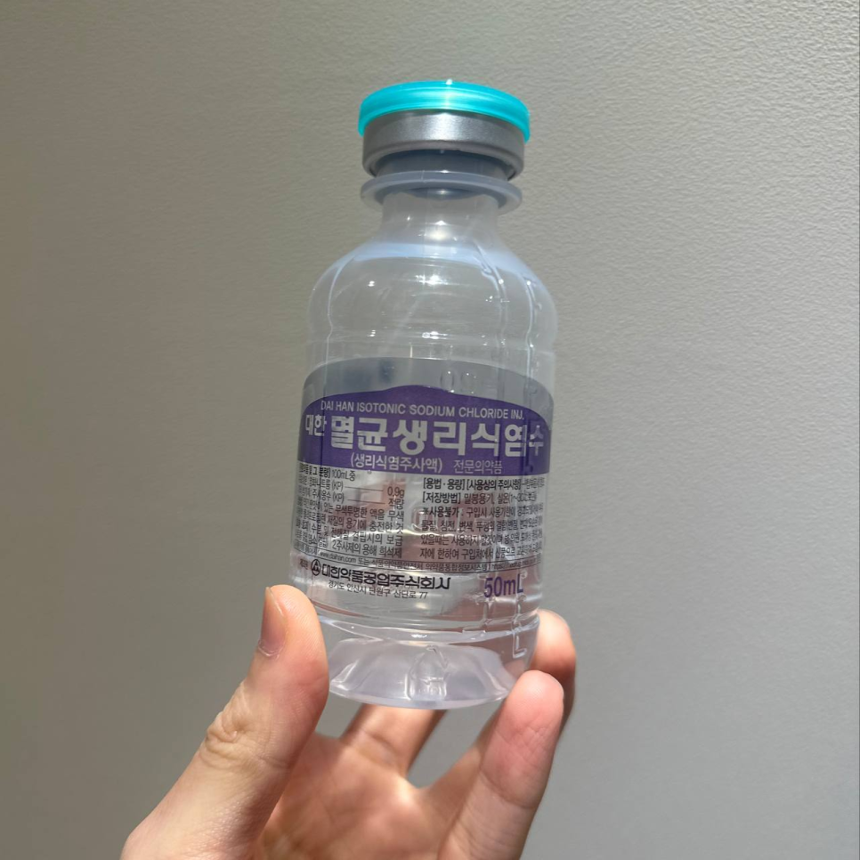 손으로 대한 멸균생리식염수 50ml 병을 들고 있는 모습 — 서울 바로한의원 초음파 약침·도침