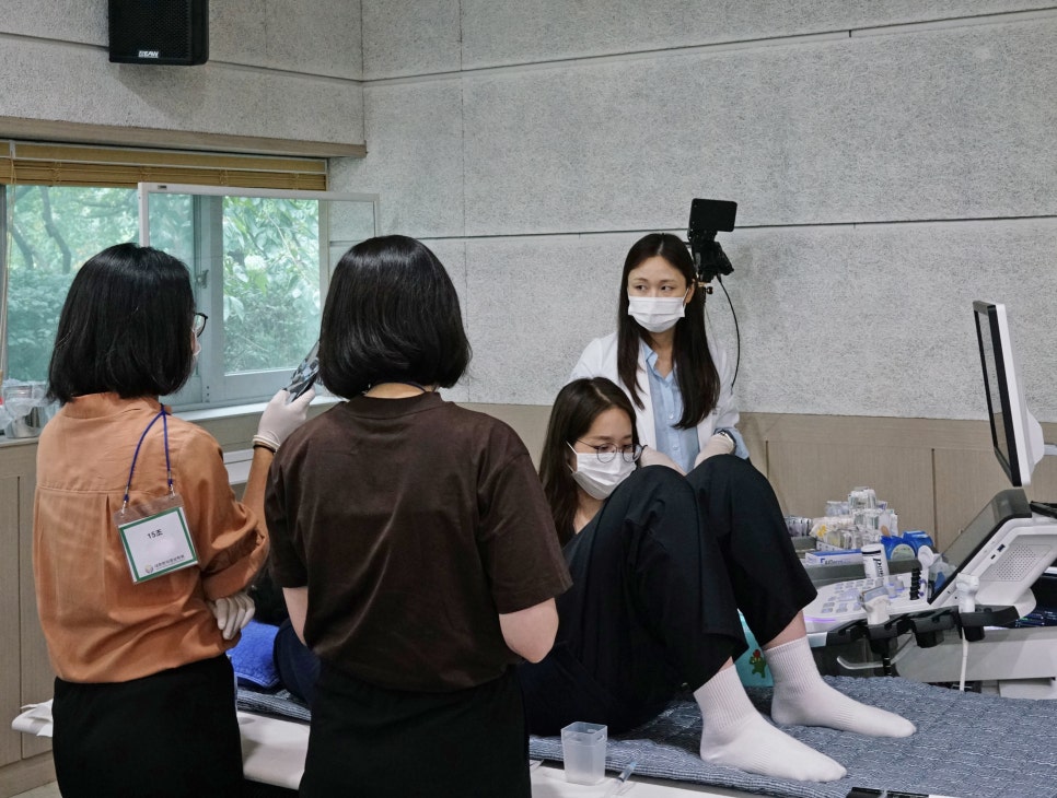 초음파 기기를 이용해 실습하는 여성들과 이를 지켜보는 모습 — 대한한의영상학회 초음파 약침·도침 강의 | 서울 바로한의원 문지현 원장