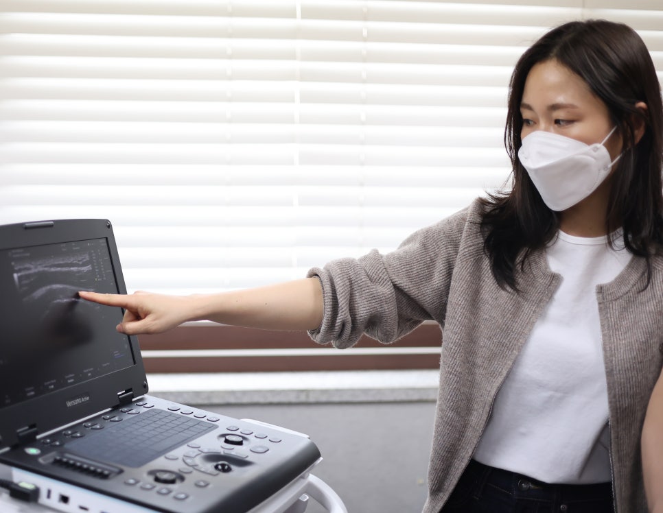 마스크를 쓴 여성이 초음파 화면을 가리키고 있다 — 초음파 정밀 진단 | 서울 바로한의원 초음파 약침·도침·침도