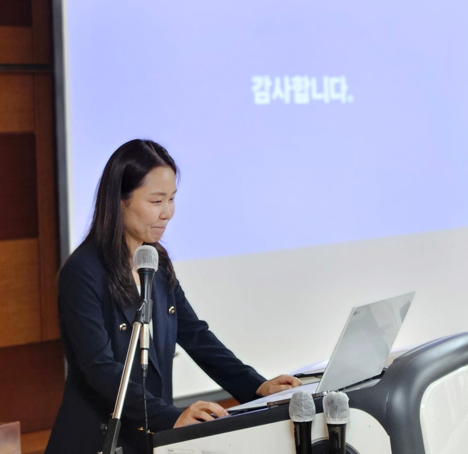 강단에서 마이크와 노트북을 앞에 두고 발표하는 여성의 모습 — 대한한의영상학회 초음파 약침·도침 강의 | 서울 바로한의원 문지현 원장