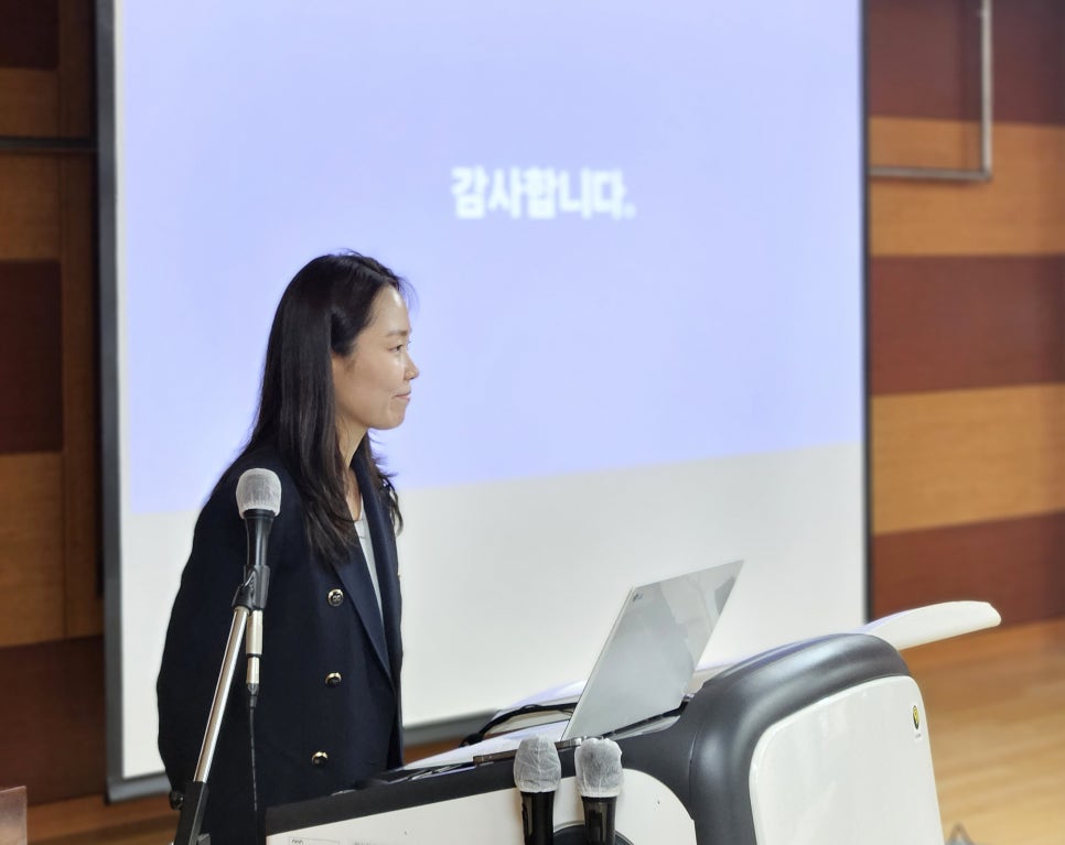 마이크가 놓인 강단에 서서 옆을 바라보는 여성. 뒤편 화면에는 '감사합니다'라는 문구가 보인다 — 대한한의영상학회 초음파 약침·도침 강의 | 서울 바로한의원 문지현 원장