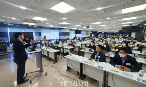 정장 차림의 남성이 연단에서 마이크를 잡고 강연하고 있으며, 많은 청중이 테이블에 앉아 경청하고 있다 — 대한한의영상학회 초음파 약침·도침 강의 | 서울 바로한의원 안태석 원장